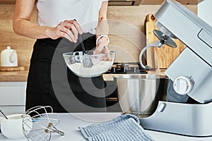 Woman cooking at kitchen and using kitchen machine