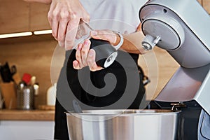 Woman cooking at kitchen and using kitchen machine