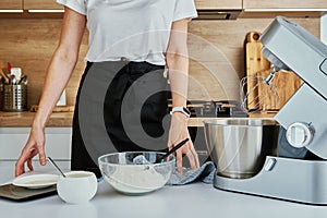 Woman cooking at kitchen and using kitchen machine