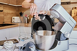 Woman cooking at kitchen and using kitchen machine