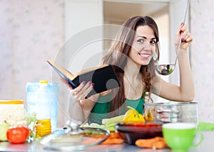 Woman cooking with ladle and cookbook