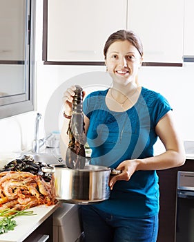 Woman cooking with lobster in home