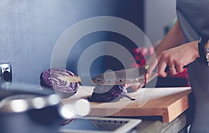 Woman cooking in new kitchen making healthy food with vegetables