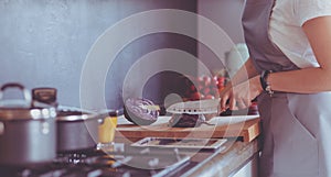 Woman cooking in new kitchen making healthy food with vegetables