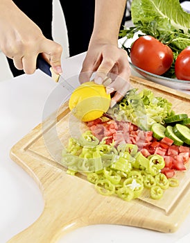 Woman cooking in new kitchen making healthy food with vegetables.