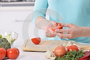 Woman cooking in new kitchen making healthy food with vegetables.