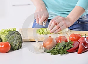 Mujer cocinando en la nueva cocina haciendo la comida saludable con verduras.