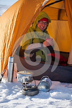 Woman cooking outside tent in wintertime