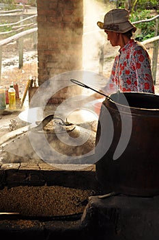 Woman cooking rice paste to make rice noodles, vietnam