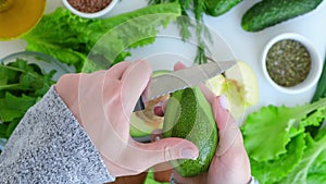 Woman cooking salad of fresh green vegetables and herbs. Raw food concept. Vegan menu. Cooking healthy diet or