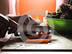 Woman cooking salad,human hands chopping vegetable,vegetarian,carrot,cucumber and red coral lettuce ,home cooking