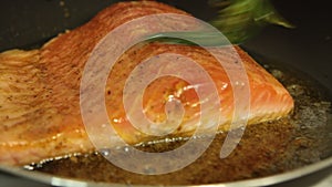 Woman cooking salmon fish at home