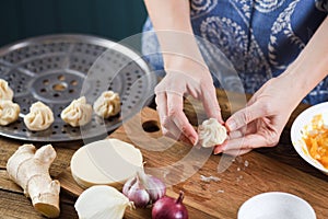 Woman cooking traditional Nepalese purse shaped dumplings momos