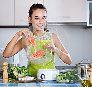 Woman cooking trout in steamer