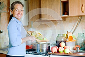 Woman cooks applesauce jam