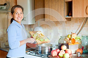 Žena kuchári jablkové pyré džem 