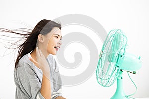 Woman cooling herself by electric fan