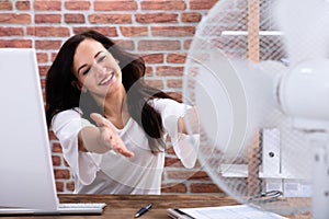 Woman Cooling Herself In Front Of Fan