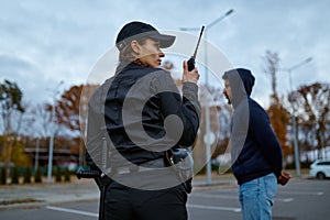 Woman cop using portable radio back view
