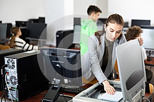 Woman copying notes on copy machine in library computer lab