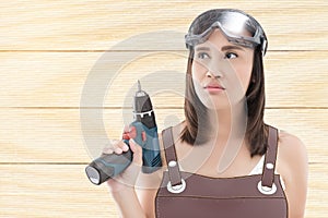 Woman with cordless drill ready for home repairs.