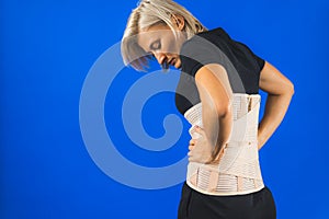 Woman with a corset on her back to support her back from pain in the back and spine, Medical concept, spinal support