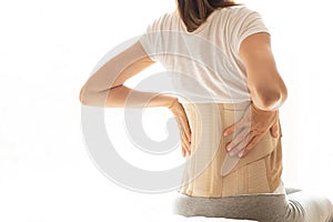 Woman with a corset on her back to support her back from pain in the back and spine, Medical concept, spinal support, wearing a