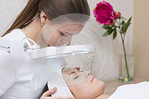 Woman and cosmetician during facial spa procedure in the beauty