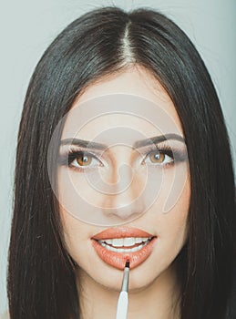 Woman cosmetics concept. Portrait of a smilling brunette woman. Girl with healthy skin and hair over gray background