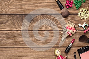 Woman cosmetics, makeup brushes, lipstick and Christmas ornaments on wood background, Flat lay top view with copy space. Christmas