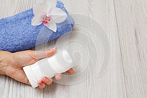 Woman cosmetics and towel on a wooden background