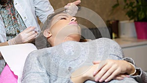 Woman in cosmetology cabinet. Cosmetologist is doing injection. woman receives an injection in the head. The concept of