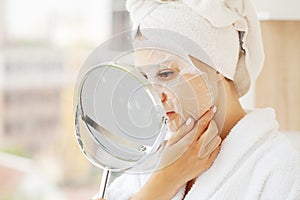 Woman with cotton face mask in beauty salon