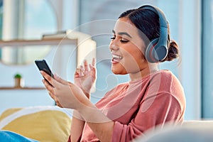 Woman on couch, smartphone and headphones for music, audio and connectivity in lounge. Hispanic female, girl and headset
