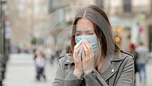 Woman coughing in the street with protective mask