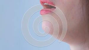 Woman coughs on white background during coronavirus quarantine, mouth closeup.