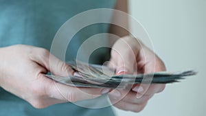 Woman counting cash money, hands in frame. UAE dirhams.