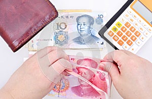 Woman counting Chinese yuan banknotes