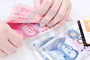 Woman counting Chinese yuan banknotes