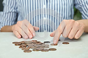 Woman counting coins at light table