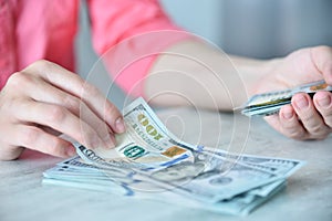 Woman counting dollars on table