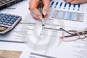 Woman counting financial data analyzing with calculator