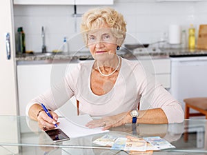 Woman counting her expenses using smartphone