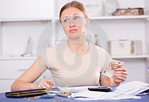 Woman counting money for paying bills