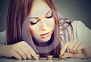 Woman counting money stacking up coins