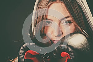 Woman cover face with boxing gloves.