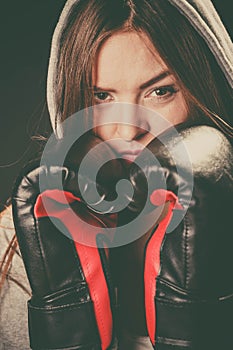 Woman cover face with boxing gloves.