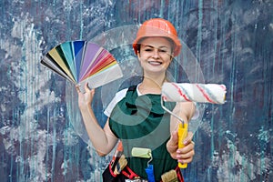 Woman in coverall holding roller and color swatch on abstract background