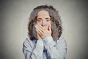 Woman covering closed mouth with hands. Speak no evil