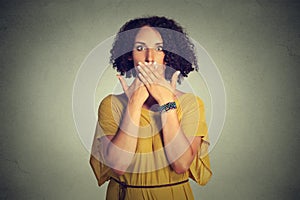 Woman covering closed mouth with hands. Speak no evil concept